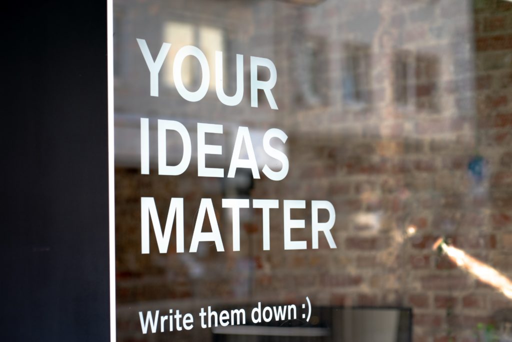 window with text "your ideas matters, write them down" on it