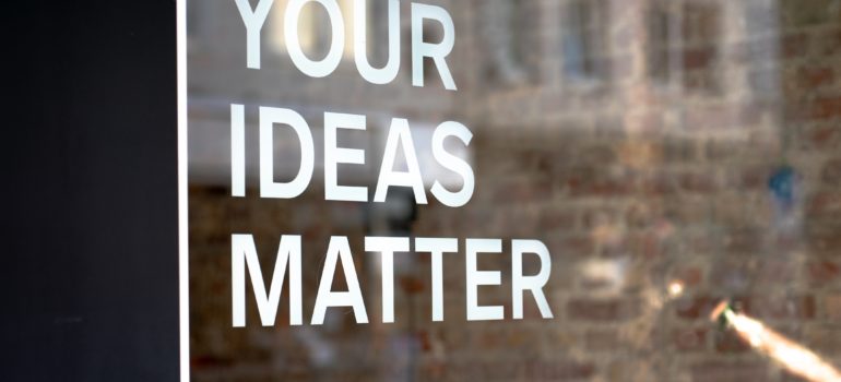 window with text "your ideas matters, write them down" on it