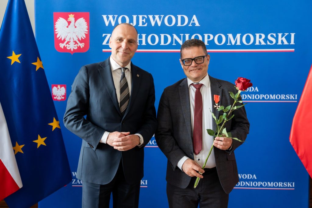 Samochowiec and Rudawski standing in front of a blue wall