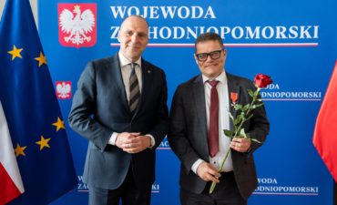 Samochowiec and Rudawski standing in front of a blue wall